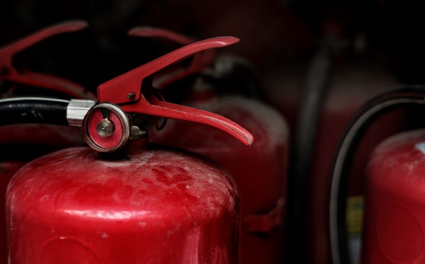 Close-up of red fire extinguishers mounted on board a ship